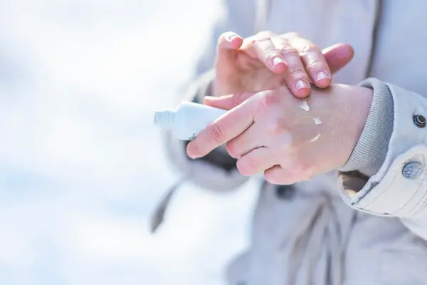  Zbliżenie na damskie dłonie, które kobieta smaruje kremem regenerującym